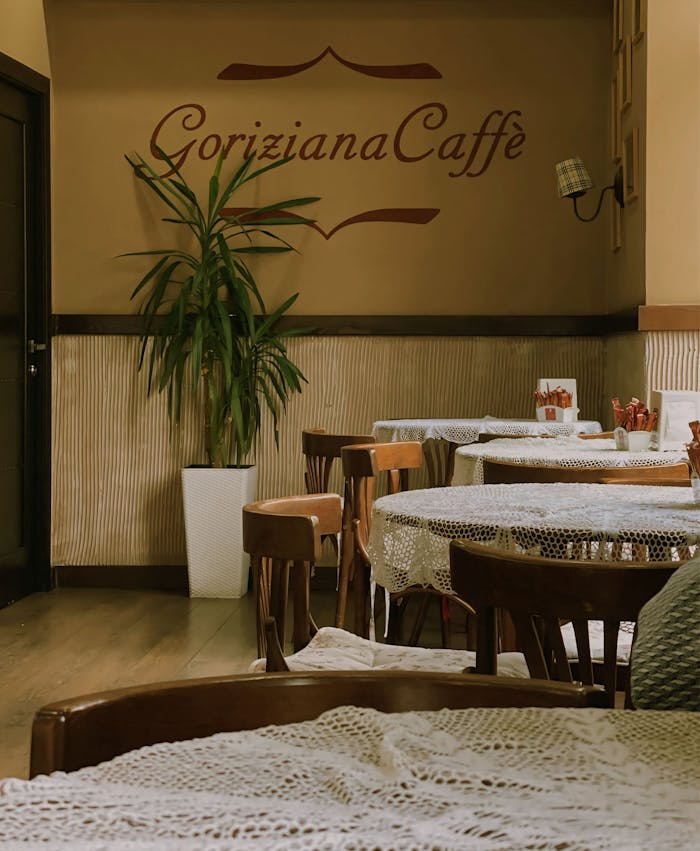 A warm and inviting cafe interior with vintage decor and lace-covered tables, perfect for relaxation.